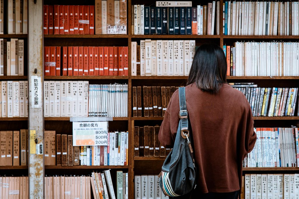 Grafika osoby przebywającej w bibliotece.